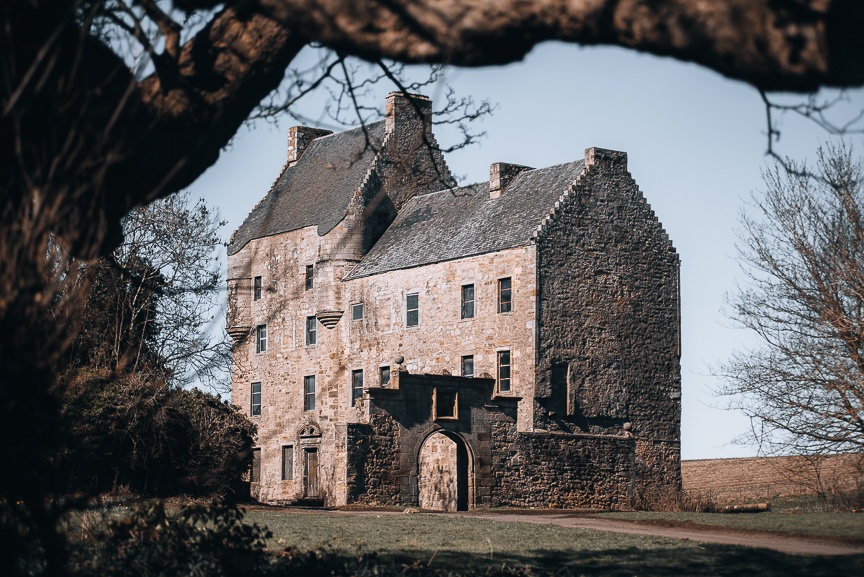 a castle with a clock tower in front of a brick building